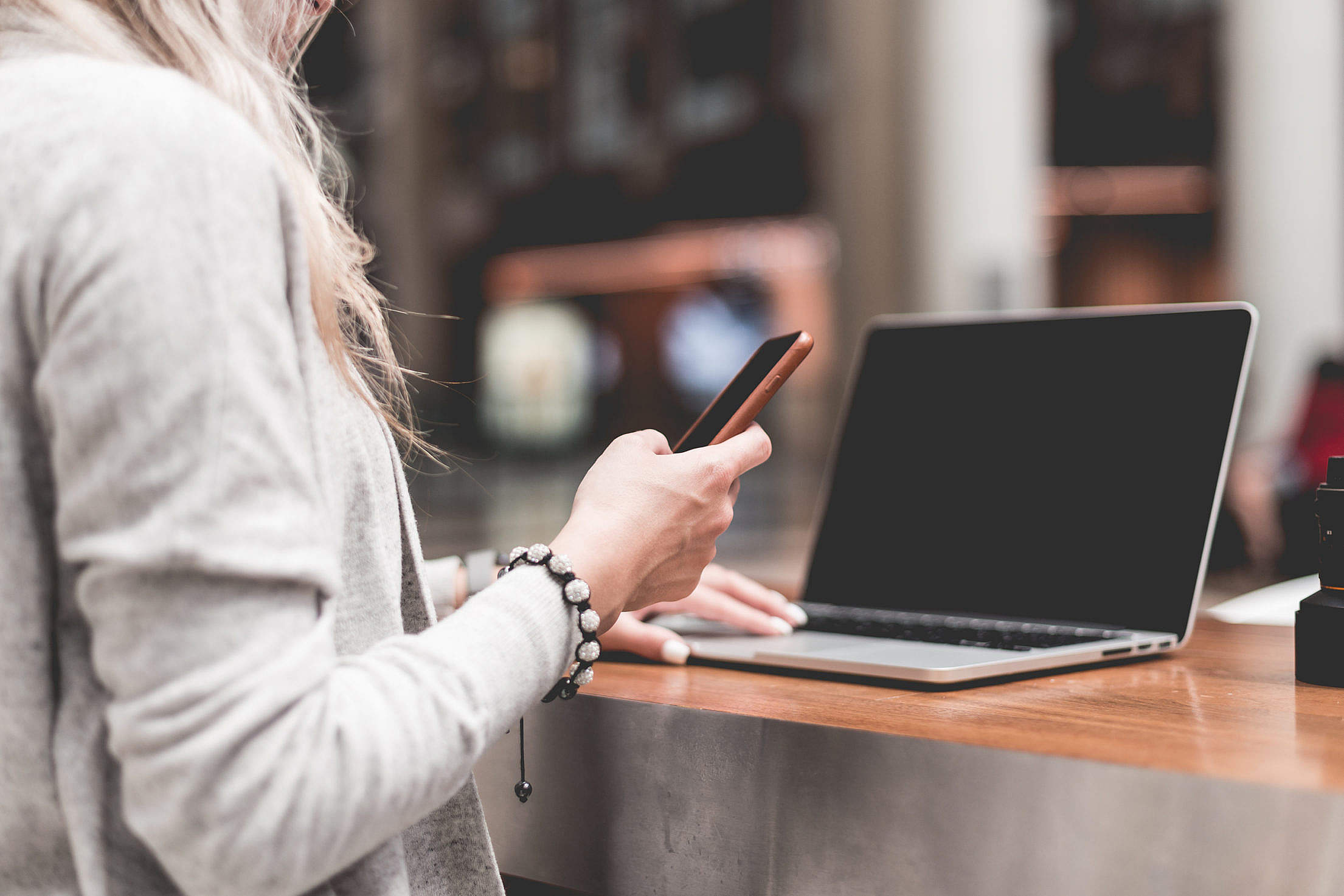 woman-using-her-smartphone-while-working-remotely-on-laptop_free_stock_photos_picjumbo_HNCK2998-2210x1474